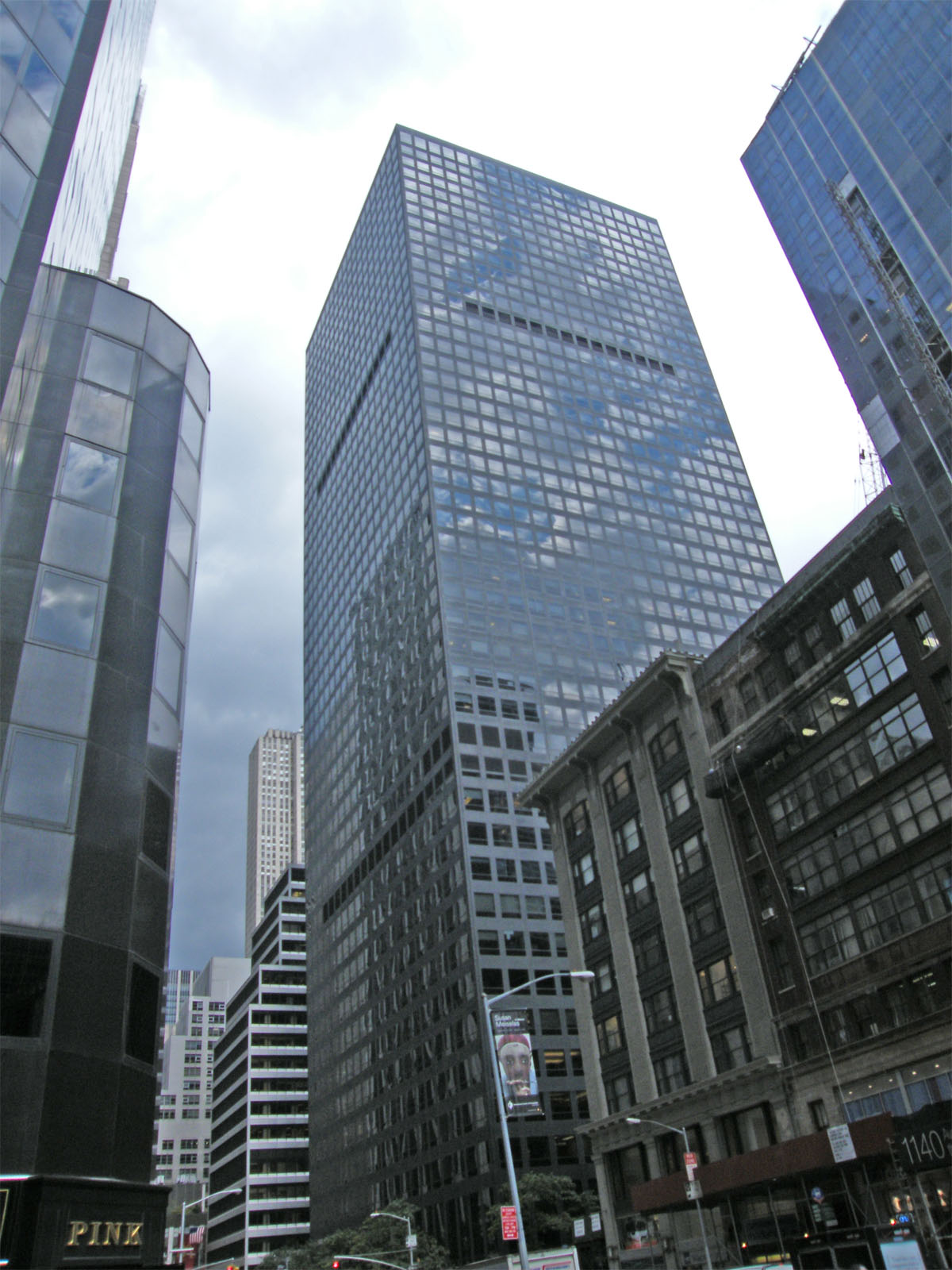 A tall dark glass office tower on a Manhattan avenue, seen from street level.